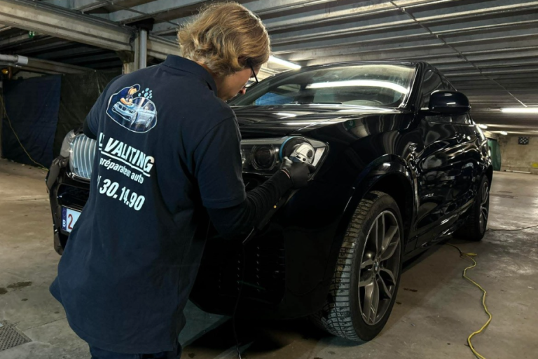 polissage de phares Un homme inspecte les phares dans un parking souterrain.